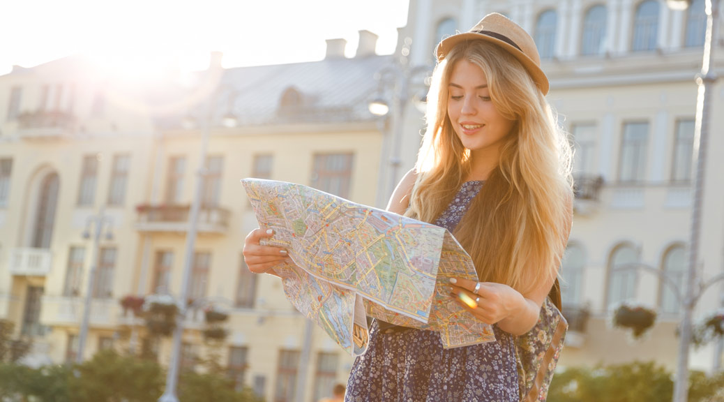 Women traveler with hat holding map on the street